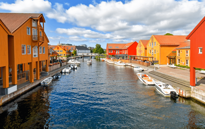 Fargerike bygninger på hver side av en kanal i Kristiansand.