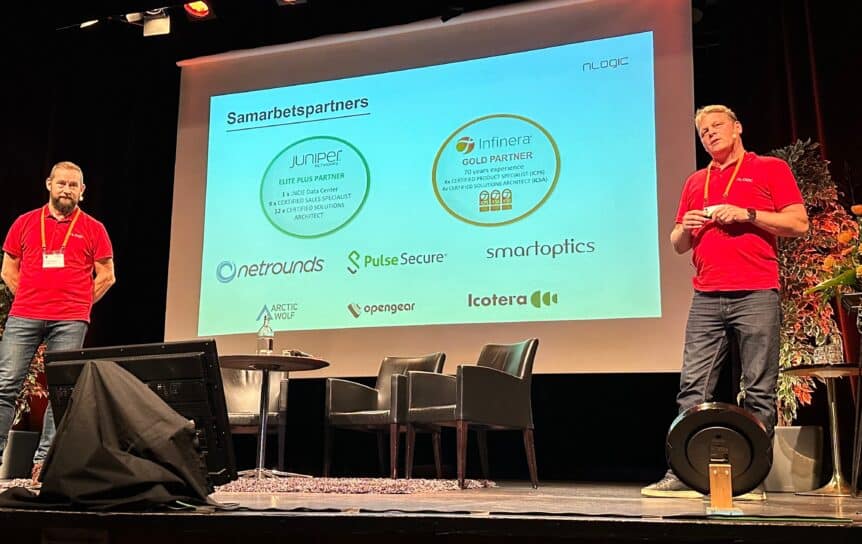 Två personer presenterar samarbetspartners på en stor skärm.