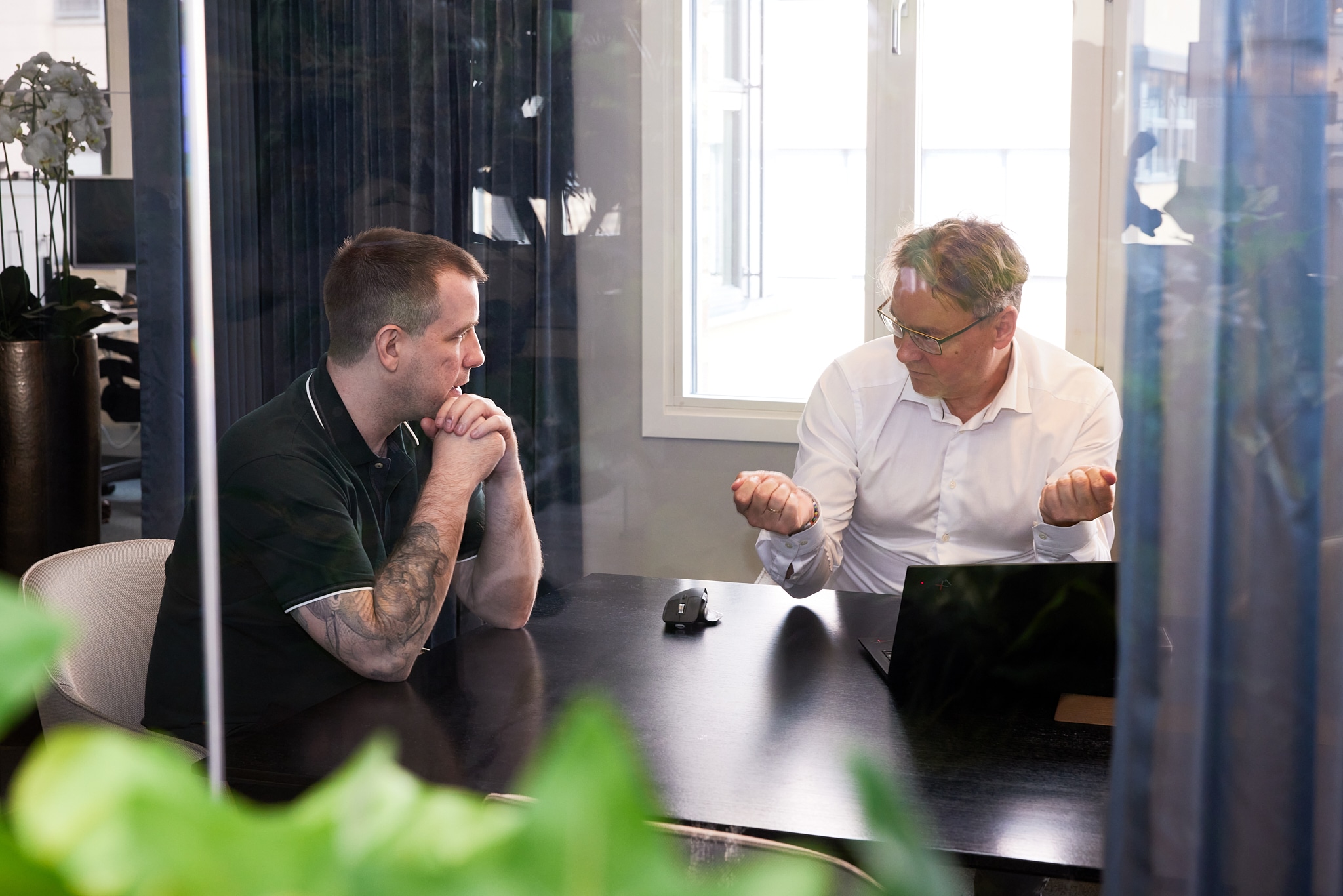 To menn snakker sammen på et kontor.