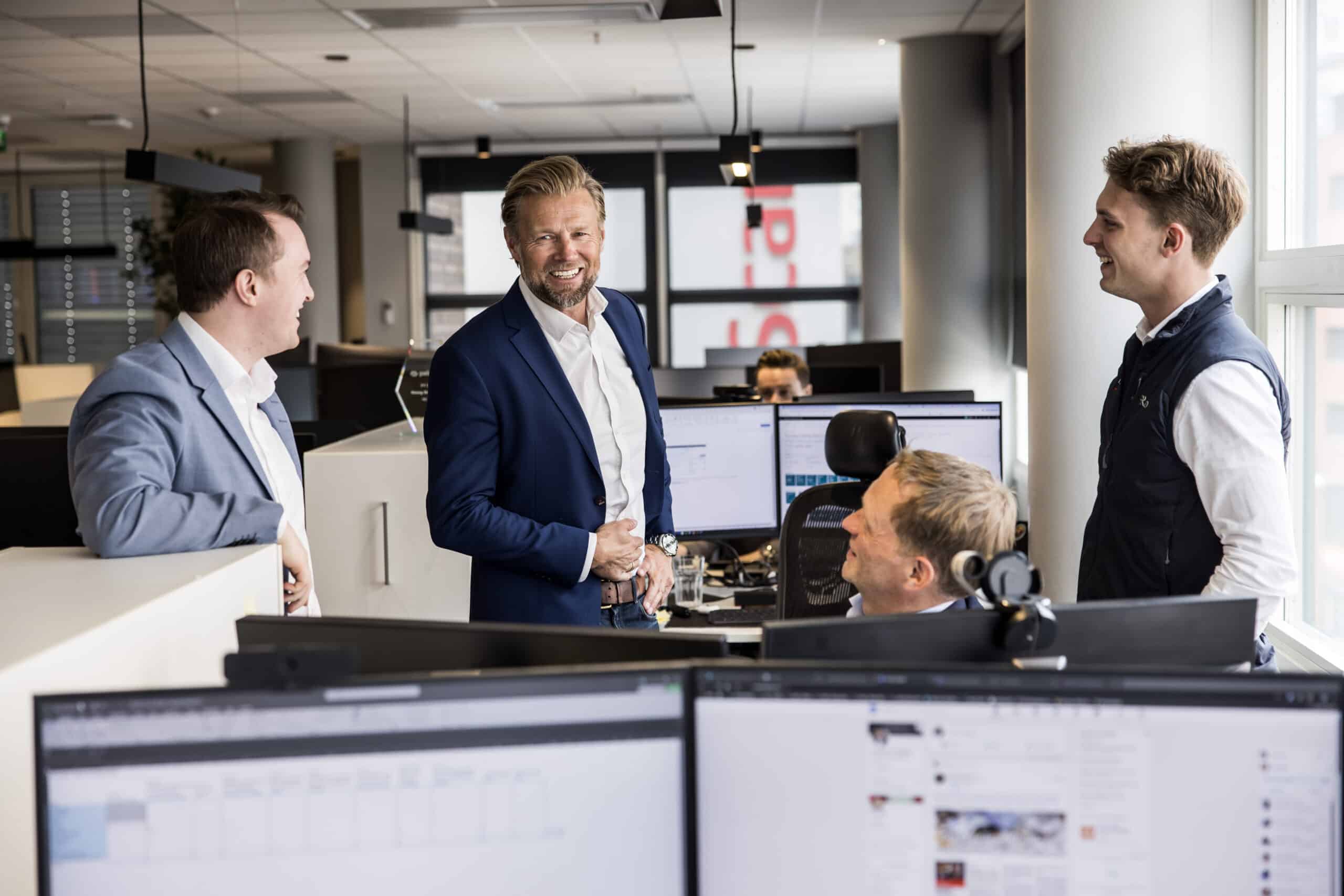 En gruppe menn i kontorlandskap.